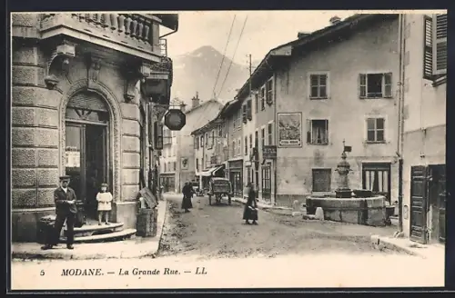 AK Modane, La Grande Rue avec fontaine et passants