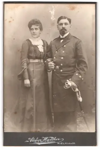 Fotografie Walther, Kiel, Offizier der Kaiserlichen Marine in Uniform mit Säbel nebst seiner Frau, Kriegsausmarsch