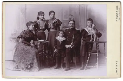 Fotografie L. Mertens, Rendsburg, Offizier in Garde Uniform mit Hund und seiner Familie im Atelier