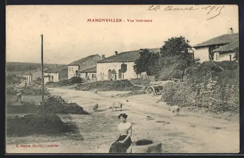 AK Manonviller, Vue intérieure du village avec femme assise et moutons sur le chemin