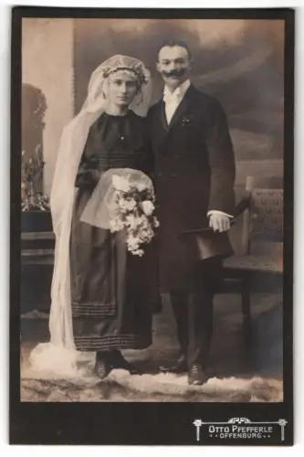 Fotografie Otto Pfefferle, Offenburg, Elegantes Hochzeitspaar mit Blumenstrauss