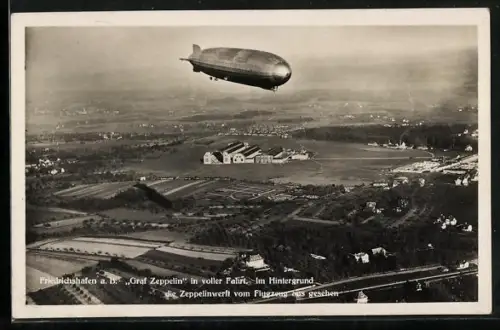 AK Friedrichshafen a. B., Graf Zeppelin in voller Fahrt, im Hintergrund die Zeppelinwerft