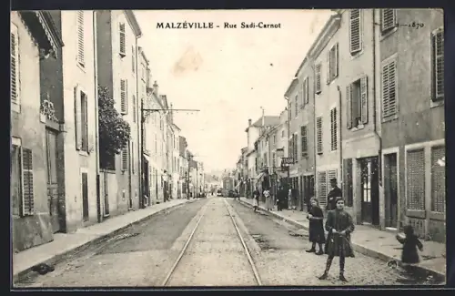 AK Malzéville, Rue Sadi-Carnot avec passants et rails de tramway