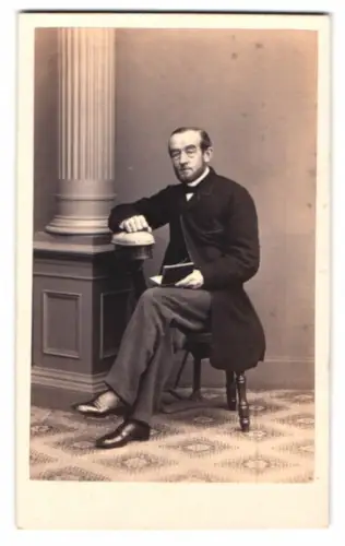 Fotografie A. Kindermann, Hamburg, Theaterstrasse 14, Mann mit Buch neben Säule