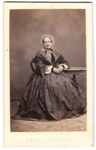 Fotografie S. Steenbock, Rostock, porträtiert ältere Dame in traditioneller Kleidung, Trockenstempel