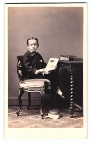 Fotografie A. Kindermann, Hamburg St. Georg, Böckmannstrasse 33, Junge mit Buch am Tisch
