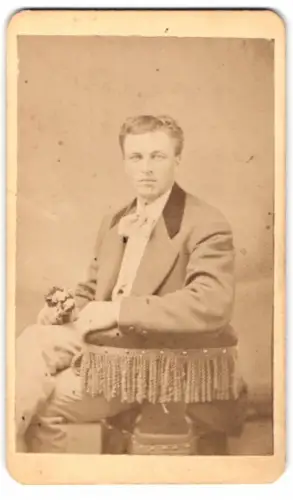 Fotografie unbekannter Fotograf und Ort, Portrait eines sitzenden Mannes mit Blumenstrauss