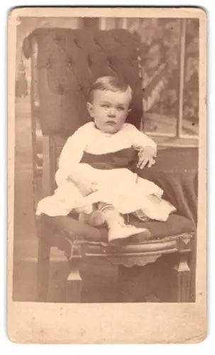 Fotografie unbekannter Fotograf und Ort, Kleinkind auf gepolstertem Stuhl 1880