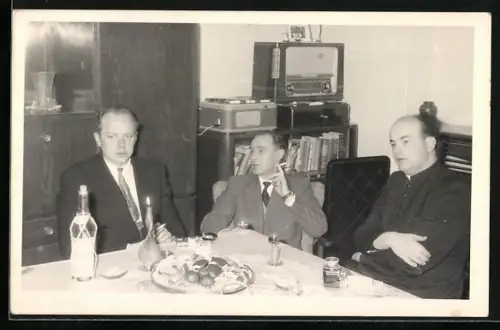 Foto-AK Drei Herren rauchen am Tisch, Im Hintergrund Radio