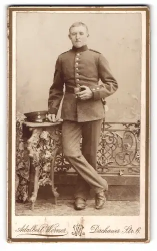 Fotografie Adalbert Werner, München, Dachauer Str. 6, Soldat in Uniform mit dekorativem Tisch