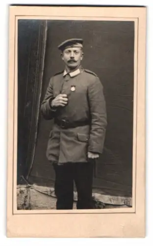 Fotografie unbekannter Fotograf und Ort, Soldat in Feldgrau Uniform mit Krätzchen