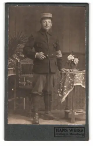 Fotografie Hans Weiss, Erding u. Moosburg, Soldat in Uniform mit Gamaschen und Armbinde