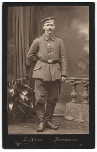 Fotografie L. Heine, Pirmasens, Soldat in Feldgrau Uniform neben Dekoration