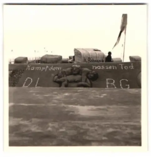 Fotografie Ansicht Dahme / Ostseebad, Sandburg mit DLRG Spruch: Kampf dem nassen Tod, Muschebild, 1957