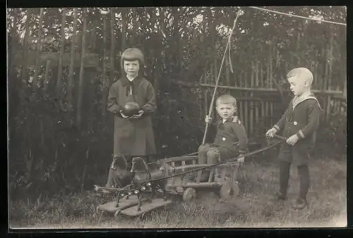 Foto-AK Kinder spielen mit einem Wagen und Spielzeugpferden