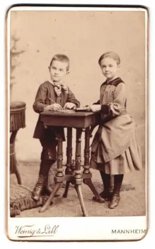 Fotografie Wenig & Lill, Mannheim, Kunststrasse 4 No. 11, Zwei Kinder an einem Tisch stehend