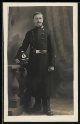 Foto-AK Polizist mit langem Mantel im Atelier