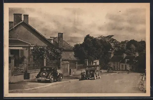 AK Reuilly, Route d`Issoudun avec voitures anciennes et maisons bordant la rue