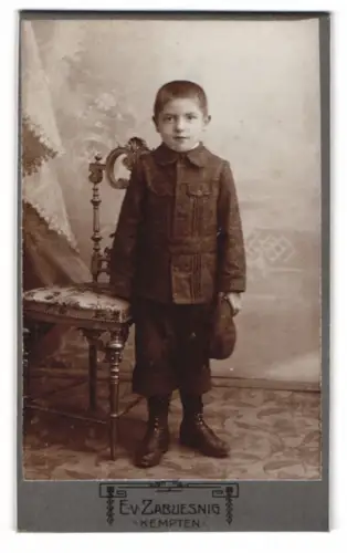 Fotografie E. v. Zabuesnig, Kempten, Bahnhofstr. T.1, Junge im Anzug neben einem Stuhl