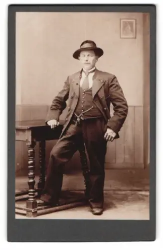 Fotografie unbekannter Fotograf und Ort, Eleganter Herr mit Hut an einem Tisch