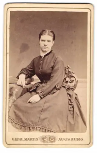 Fotografie Gebr. Martin, Augsburg, Sitzende Frau in dunklem Kleid