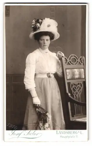 Fotografie Josef Sutor, Landsberg a.L., Hauptplatz 11, Frau mit elegantem Hut und Blumen