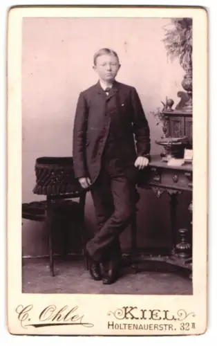 Fotografie C. Ohle, Kiel, Holtenauerstr. 32, Porträt eines Jungen mit Sekretär