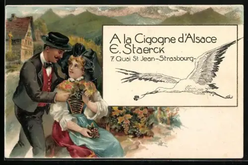 AK Strasbourg, La Cigogne d`Alsace, 7. Quai St. Jean, fliegender Storch, Paar in Tracht mit Weintrauben