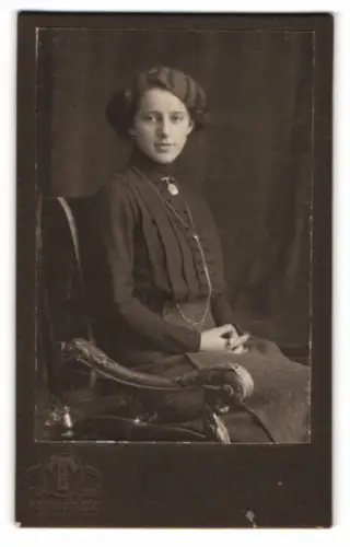 Fotografie Hermann Tietz, München, Bahnhofplatz, Porträt einer sitzenden jungen Frau