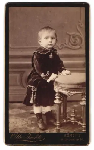 Fotografie Otto Faethe, Görlitz, Grüner Graben 36, Kind lehnt an einem Hocker
