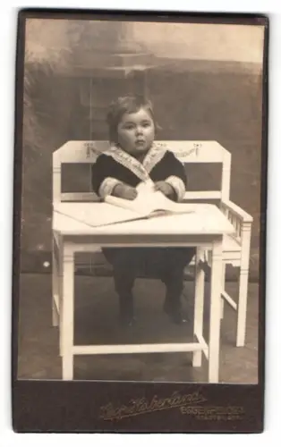 Fotografie Leopold Haberland, Eggenfelden, Kleinkind am Tisch sitzend