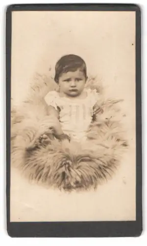 Fotografie Ferdinand Pöschl, Planegg, Kleinkind auf Fellunterlage