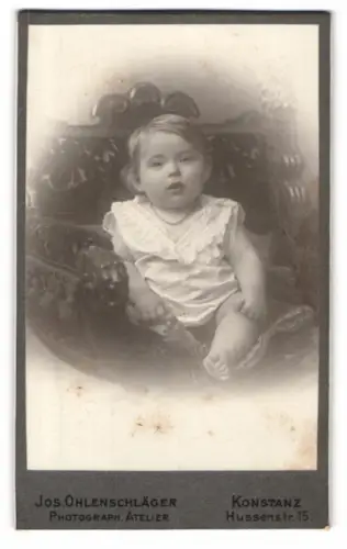 Fotografie Jos. Ohlenschläger, Konstanz, Hussenstr. 15, Kleinkind auf einem Sessel
