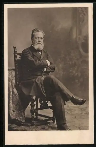 AK Bürgermeister Carl Lueger sitzt im Anzug mit überschlagenen Beinen auf einem Stuhl