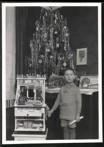 Fotografie junger Knabe mit seinem Spielzeug Kaufmannsladen zu Weihnachten