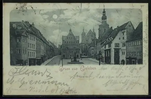 Mondschein-AK Eisleben, Strassenpartie mit Geschäft und Denkmal