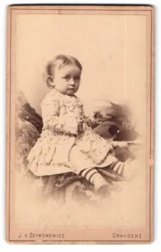 Fotografie J. V. Szymonowicz, Graudenz, Marienwerderstr. 27, Kleinkind in gestreiften Socken