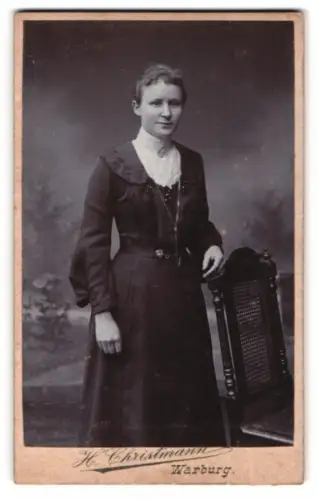 Fotografie H. Christmann, Warburg, Dame im eleganten Kleid mit Stuhl