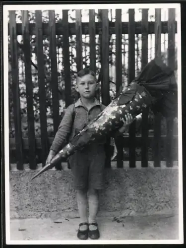 Fotografie junger Knabe mit riesiger Zuckertüte zum Schulanfang
