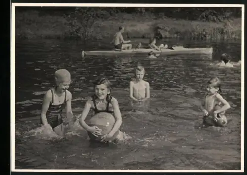 Fotografie Kinder in Badenanzügen beim Spielen im Wasser