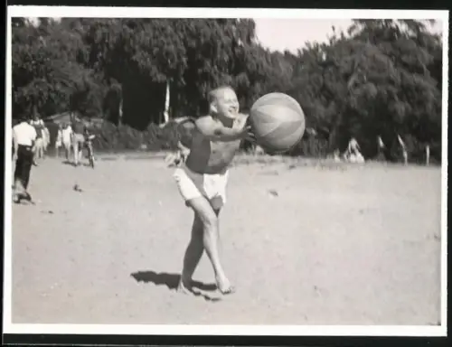 Fotografie Mann in Badehose spielt mit Strandball