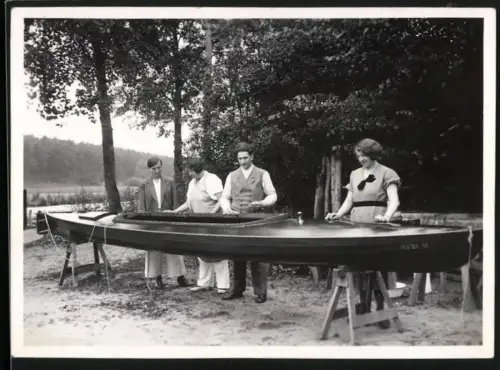 Fotografie Mann und Frau polieren ihr Ruderboot Mädi II, Rudersport