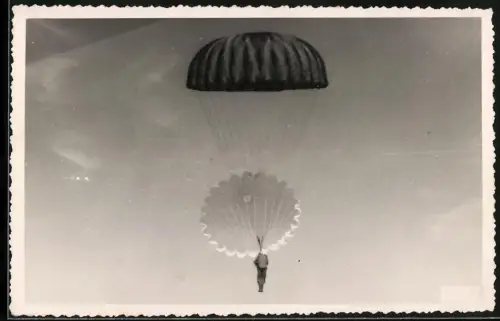 Fotografie Fallschirmjäger am Rundkappen Fallschirm gleitet zu Boden
