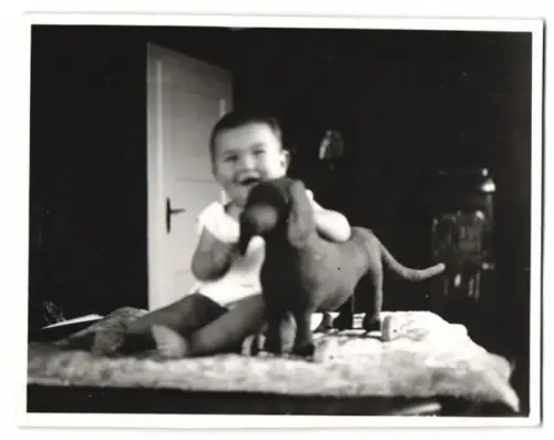 Fotografie kleines Kind mit Spielzeug Dackel auf Rollen, Rolldackel