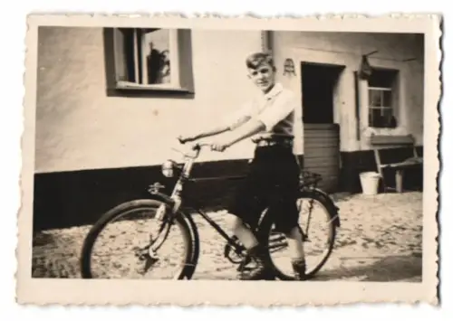 Fotografie junger Knabe auf seinem Fahrrad mit Schutzblechfigur