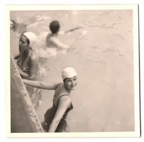 Fotografie junge Frauen in Badeanzügen mit Schwimmhaube im Pool