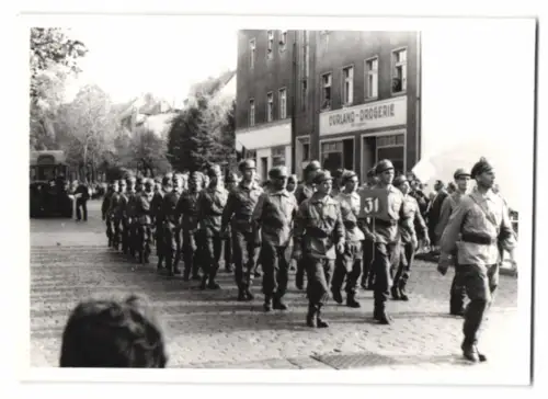 Fotografie Soldaten in Uniform maschieren durch den Ort
