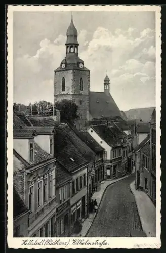 AK Hettstedt /Südharz, Wilhelmstrasse mit Geschäften und Kirche