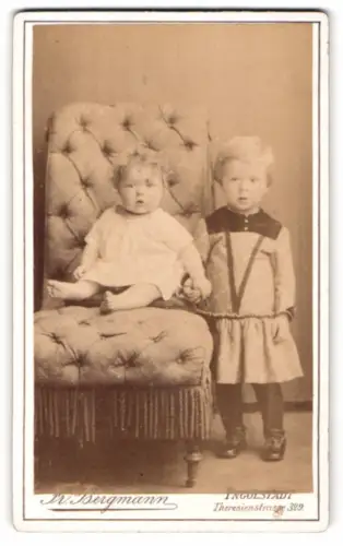 Fotografie Fr. Bergmann, Ingolstadt, Theresienstrasse 329, Zwei Kleinkinder auf einem gepolsterten Stuhl