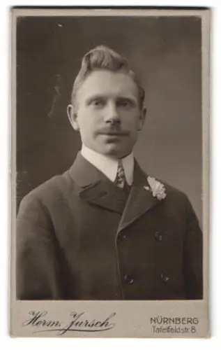 Fotografie Herm. Jursch, Nürnberg, Tafelfeldstr. 8, Porträt eines Mannes mit Blumenanstecker